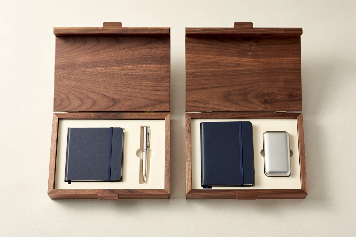 Event gift box design concept showing two wooden kit layouts with matching outer shells
