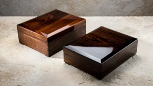 Two dark wood-grain presentation boxes with clear lacquer and reflected studio light