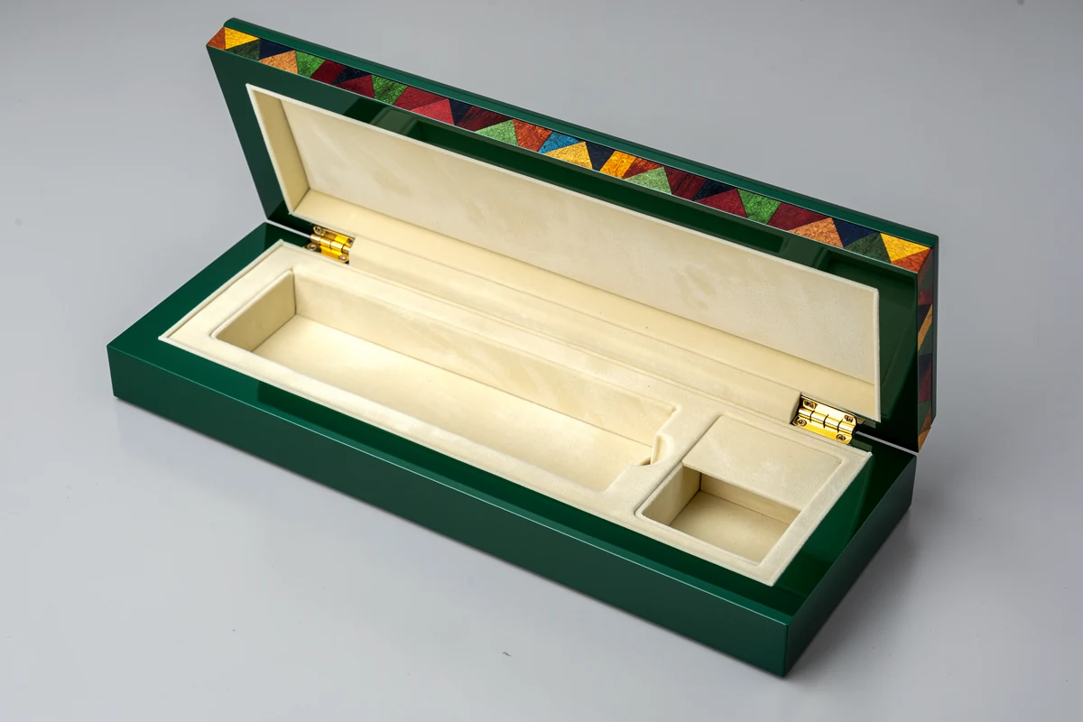 Open emerald presentation case showing ivory compartments and rear hinges