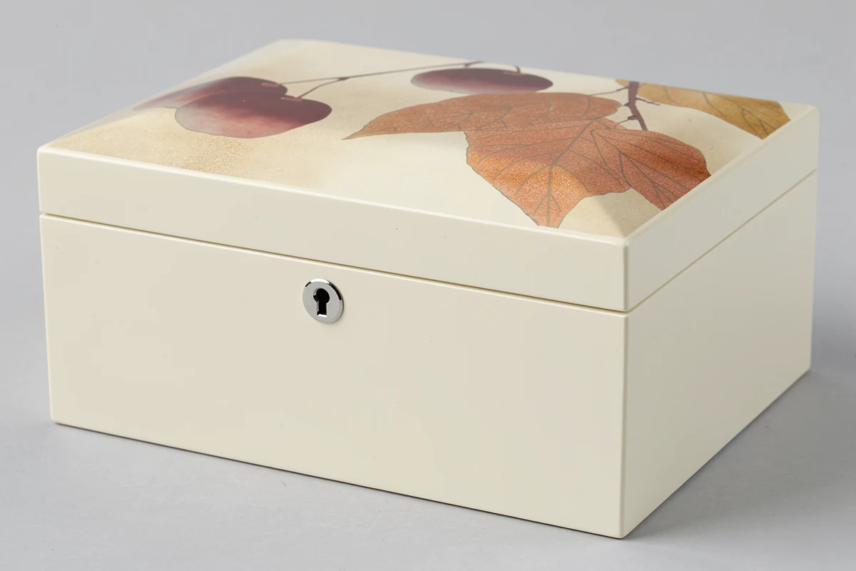 Ivory lacquer wooden box with a small front keyhole and multicolor lid artwork