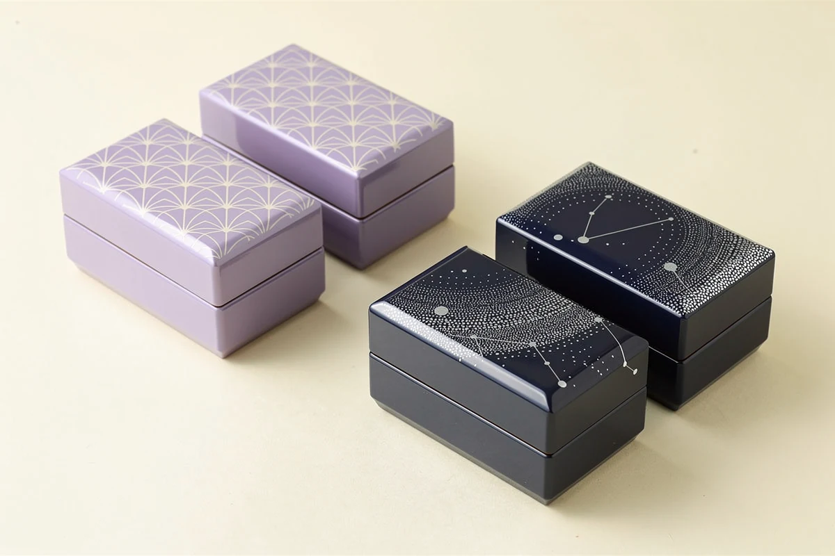 Lavender and dark blue decorated wooden boxes arranged in separate groups